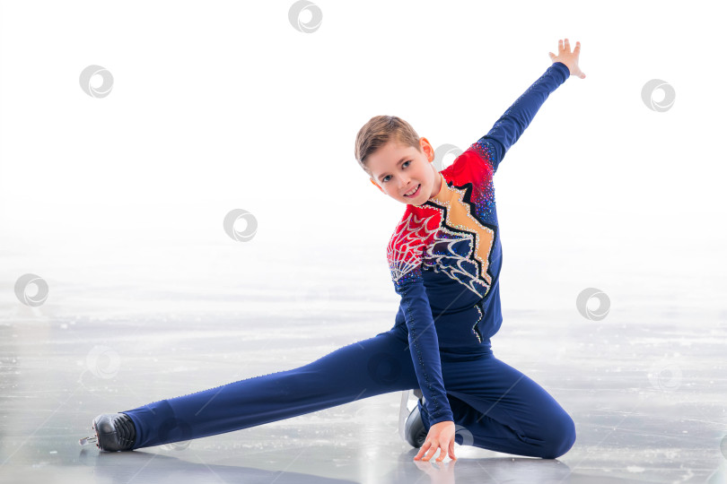 Скачать Мальчик-фигурист в шапке Санта-Клауса катается на коньках. фотосток Ozero