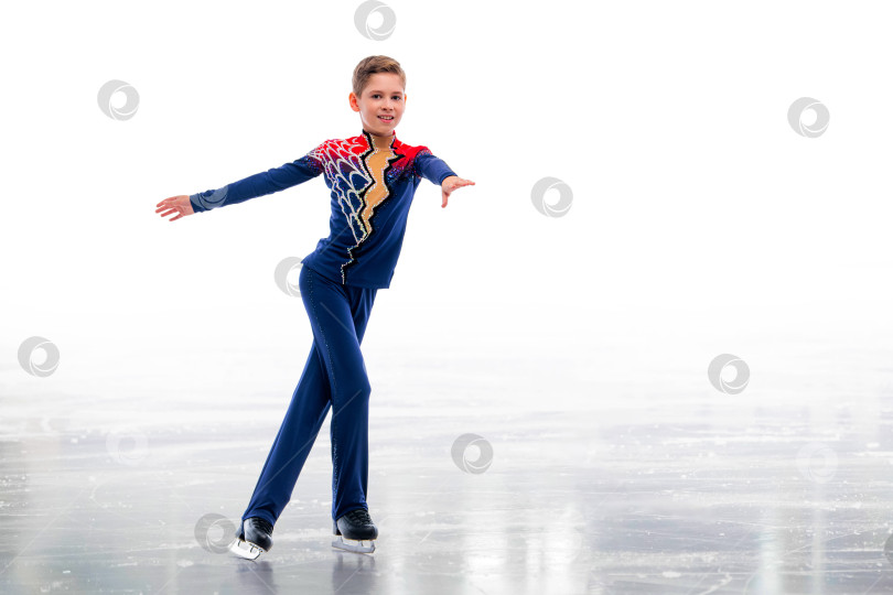 Скачать Мальчик-фигурист в шапке Санта-Клауса катается на коньках. фотосток Ozero