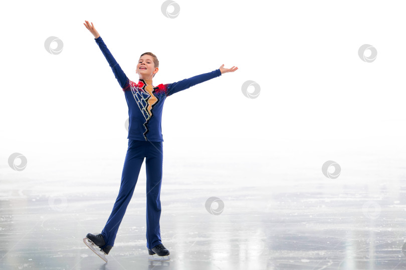 Скачать Мальчик-фигурист в шапке Санта-Клауса катается на коньках. фотосток Ozero