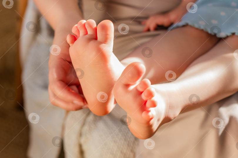 Скачать Детские ножки крупным планом. Рука матери щекочет пятки. фотосток Ozero