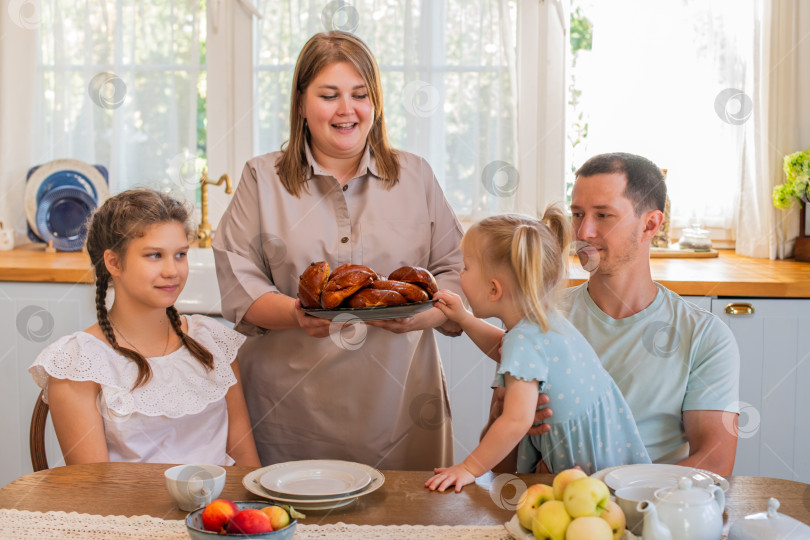 Скачать Семья наслаждается свежеиспеченной выпечкой на кухне фотосток Ozero
