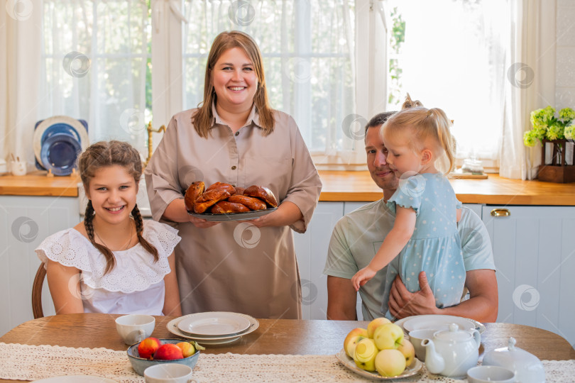 Скачать Семья наслаждается совместным завтраком на уютной кухне фотосток Ozero