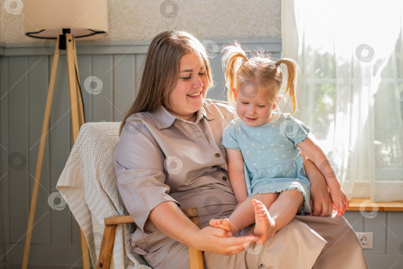 Скачать Мать играет со своей маленькой дочкой и щекочет ее босые ножки. фотосток Ozero