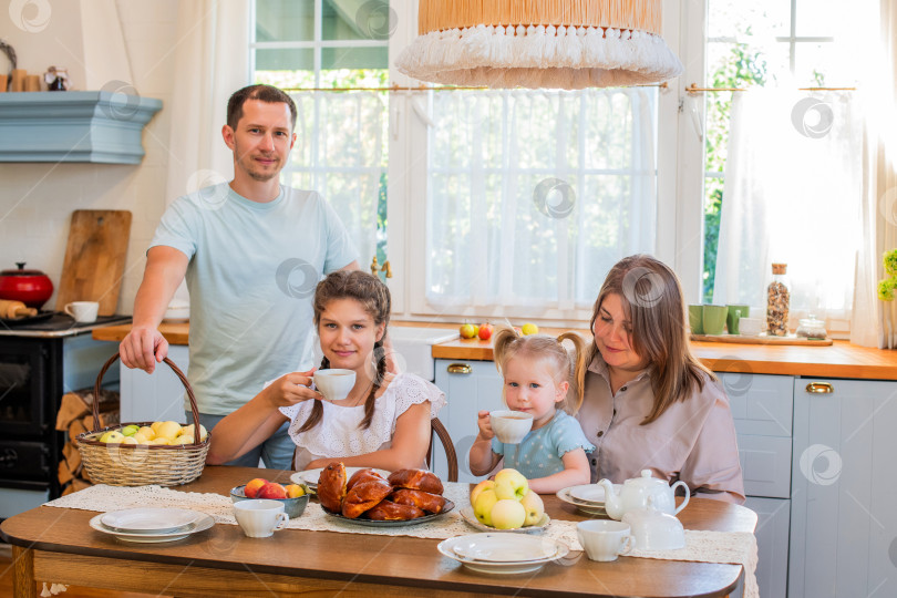 Скачать Семья наслаждается совместным завтраком на уютной кухне фотосток Ozero