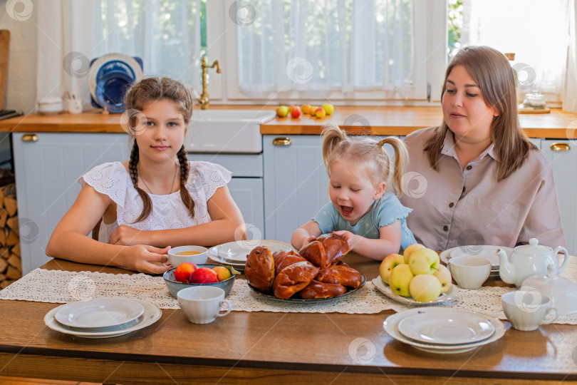 Скачать Семья наслаждается свежеиспеченной выпечкой на кухне фотосток Ozero
