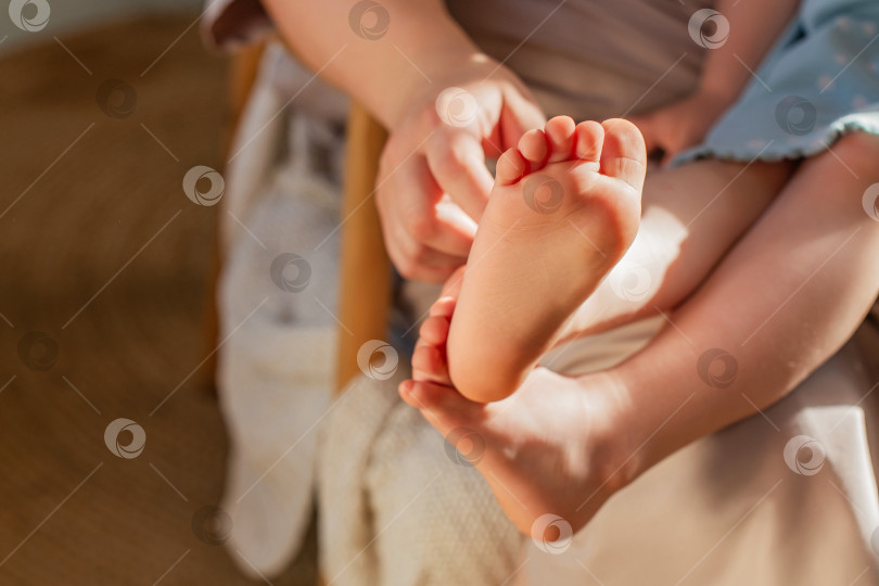 Скачать Детские ножки крупным планом. Рука матери щекочет пятки. фотосток Ozero