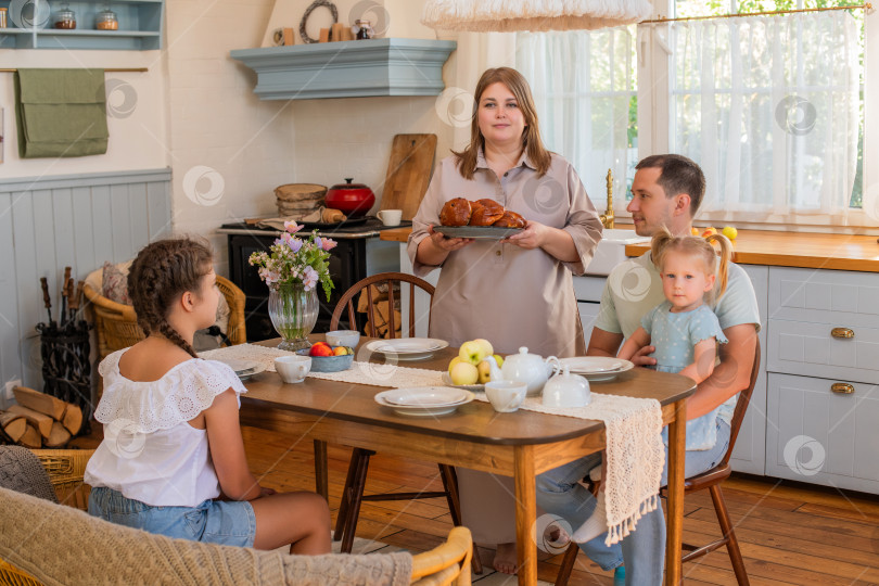 Скачать Семья наслаждается совместным завтраком на уютной кухне фотосток Ozero