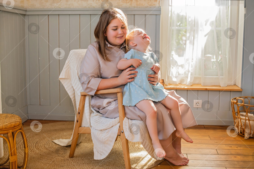 Скачать Мать играет со своей маленькой дочкой и щекочет ее босые ножки. фотосток Ozero