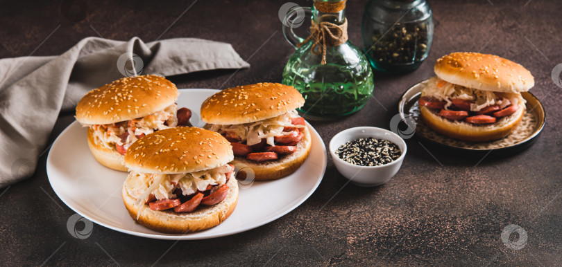 Скачать Булочки по-нью-йоркски с колбасой и квашеной капустой на тарелке на столовом веб-баннере фотосток Ozero