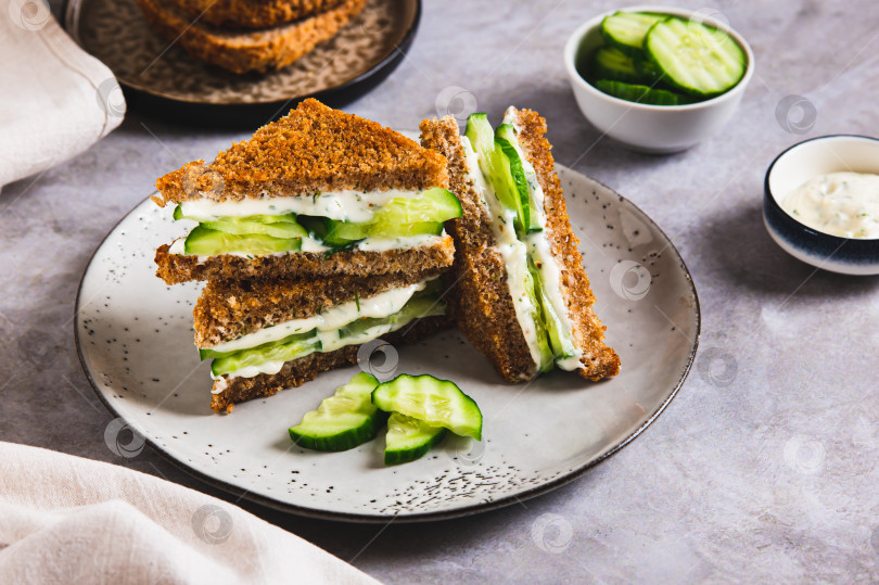 Скачать Английский сэндвич с огурцом, маслом и сыром на зерновом хлебе на тарелке на столе фотосток Ozero