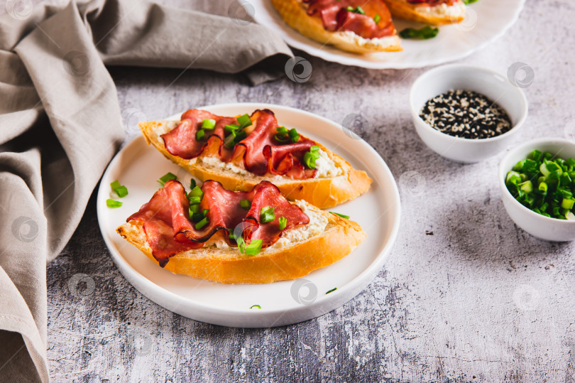 Скачать Запеченная брускетта с рикоттой и беконом на тарелке на столе фотосток Ozero