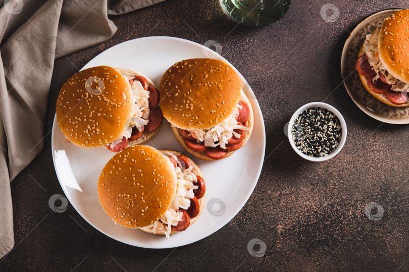 Скачать Булочки по-нью-йоркски с колбасой и квашеной капустой на тарелке, вид сверху фотосток Ozero