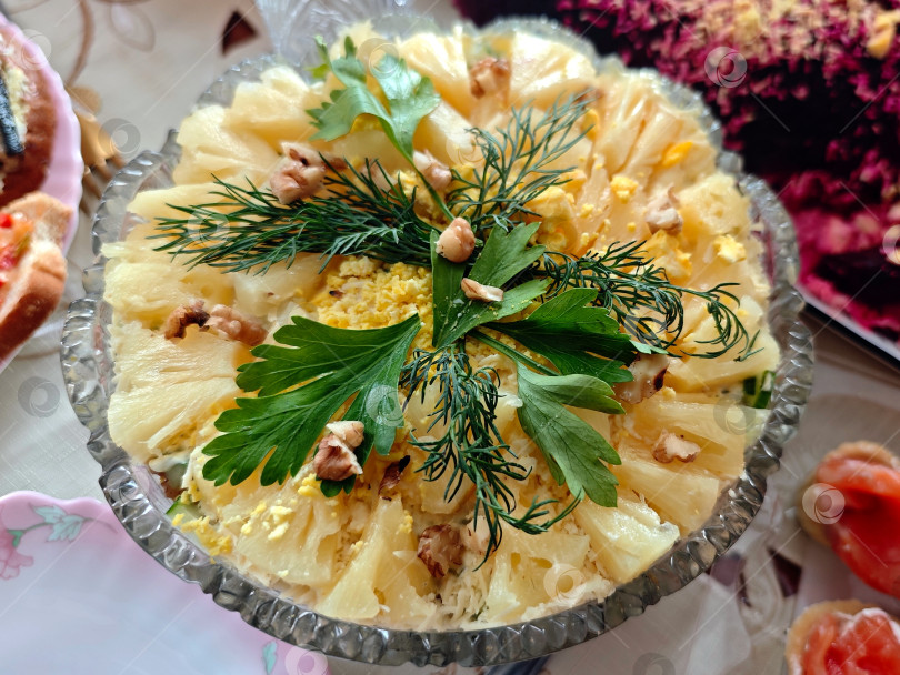 Скачать Салат с ананасами, украшенный зеленью.  Салат из ананасов, украшенный зеленью. фотосток Ozero