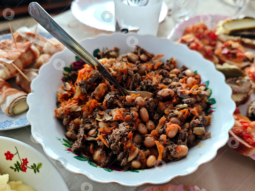 Скачать Салат с морковью, печенью и фасолью на столе. Салат с морковью, печенью и фасолью на стол. фотосток Ozero