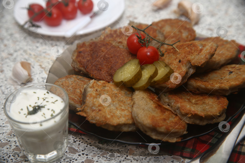 Скачать Блюдо жареные драники с солениями и овощами фотосток Ozero