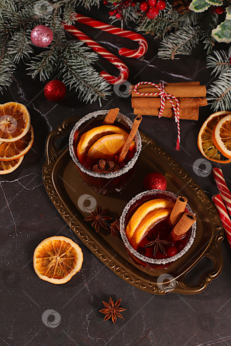 Скачать Крепкий алкогольный или безалкогольный коктейль, глинтвейн со специями, звездчатым анисом, клюквой, апельсином, яблоком и корицей, согревающий зимний напиток в холодное время года, праздничный рождественский грог, фотосток Ozero