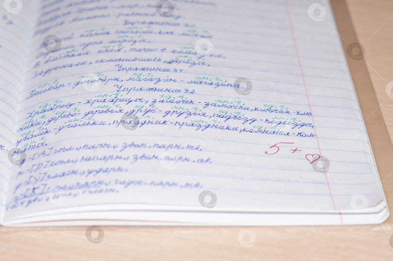 Скачать Саратов, Россия - 18 февраля 2024 года. Разворот тетради по русскому языку с оценкой пять с плюсом и сердечком от учителя фотосток Ozero