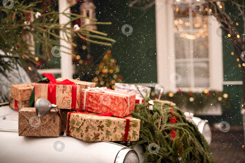Скачать Рождественский подарочный пакет на крыше автомобиля. Праздничный снежный день и зимняя атмосфера. фотосток Ozero