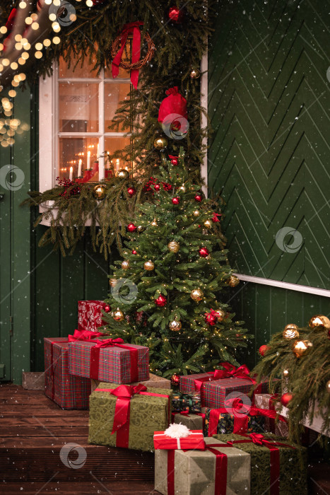 Скачать Уличное украшение рождественской елкой и праздничными подарками в снежный зимний день. фотосток Ozero