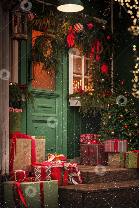 Скачать Уличное украшение рождественской елкой и праздничными подарками в снежную зимнюю ночь. фотосток Ozero