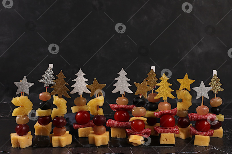 Скачать Ассорти канапе с помидорами, сыром моцарелла, салями, ананасами, оливками и виноградом на мраморном столе. Рождественские и новогодние блюда, набор закусок для праздничного стола. фотосток Ozero