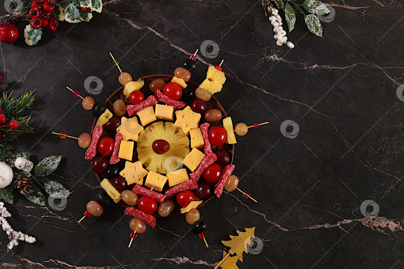Скачать Ассорти канапе с помидорами, сыром, салями, ананасами, оливками и виноградом на мраморном столе. Рождественские и новогодние блюда, набор закусок для праздничного фуршета. Концепция сочельника фотосток Ozero