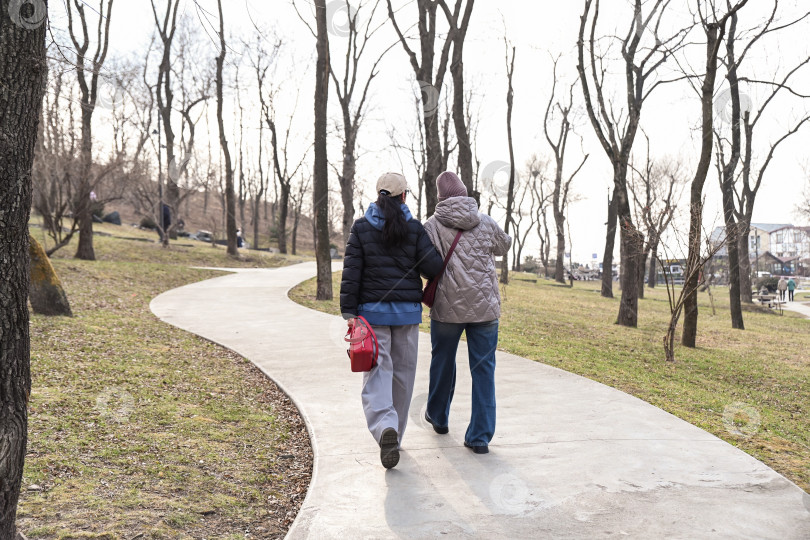 Скачать Двое русских друзей прогуливаются по Нагорному парку во Владивостоке, наслаждаясь осознанным движением и спокойной беседой, которая поддерживает благополучие, свободу и позитивную связь. фотосток Ozero