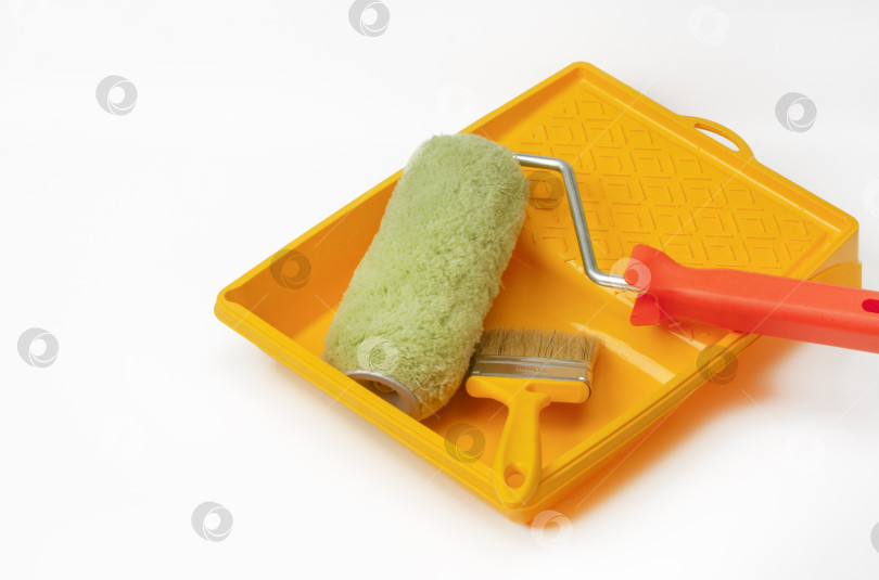 Скачать На белом фоне изображены инструменты для ремонта дома или квартиры - валик и кисть для рисования фотосток Ozero