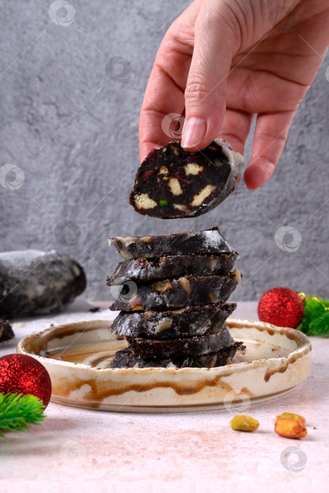 Скачать Женская рука берет кусочек шоколадной салями фотосток Ozero