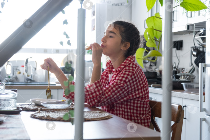 Скачать Утром девушка завтракает на кухне яичницей-болтуньей и бутербродом за столом фотосток Ozero