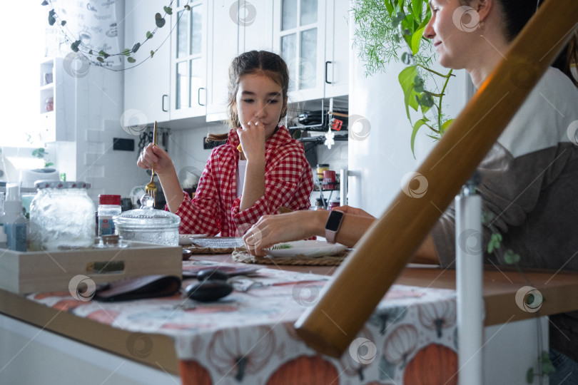 Скачать Девочка утром завтракает на кухне за столом в компании своей мамы, занимается утренними приготовлениями фотосток Ozero