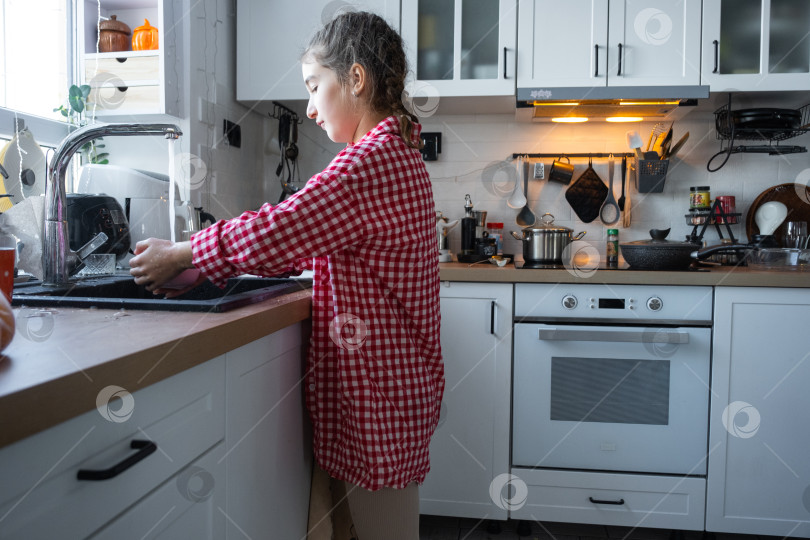 Скачать Девушка сама готовит себе завтрак на кухне, моет посуду фотосток Ozero