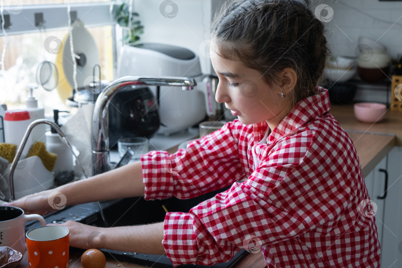 Скачать Девушка сама готовит себе завтрак на кухне, моет посуду фотосток Ozero