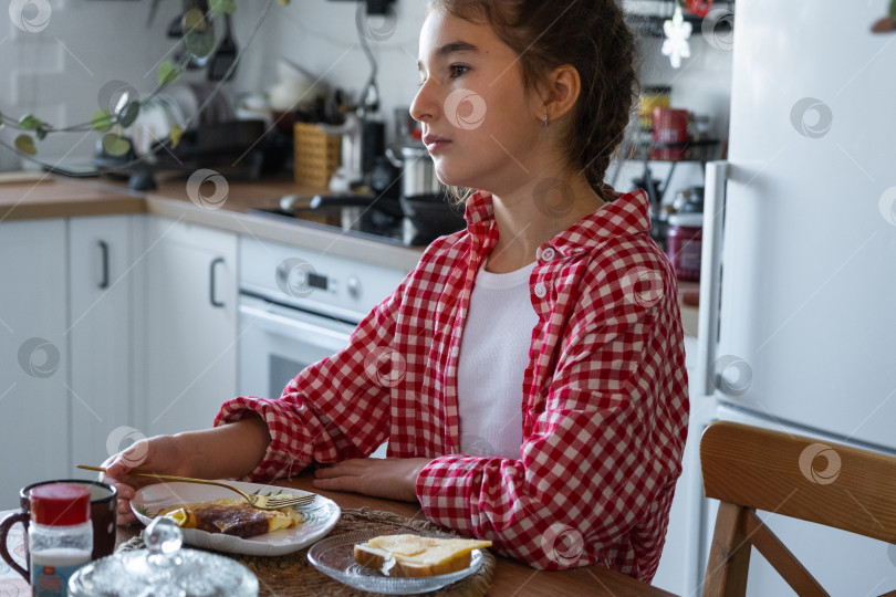 Скачать Утром девушка завтракает на кухне яичницей-болтуньей и бутербродом за столом фотосток Ozero