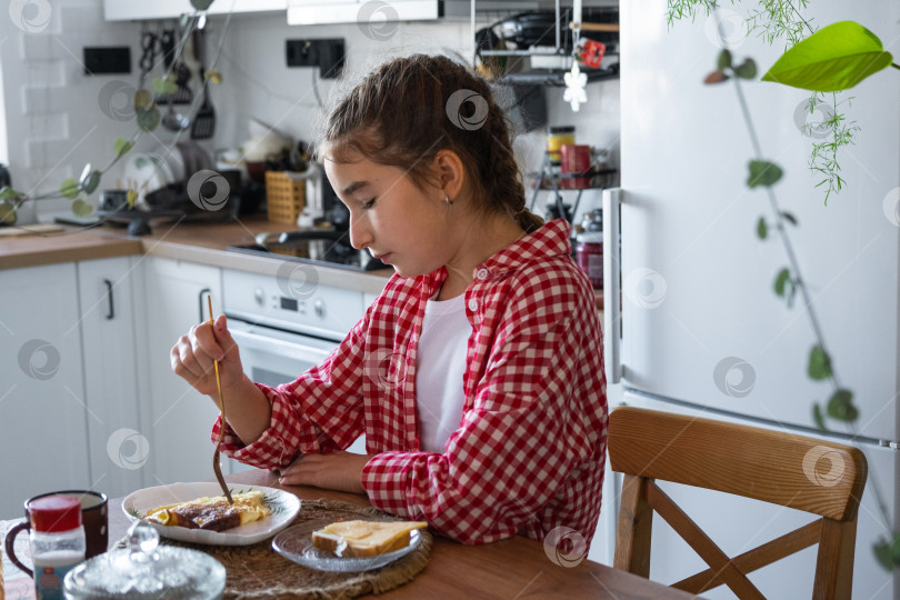 Скачать Утром девушка завтракает на кухне яичницей-болтуньей и бутербродом за столом фотосток Ozero