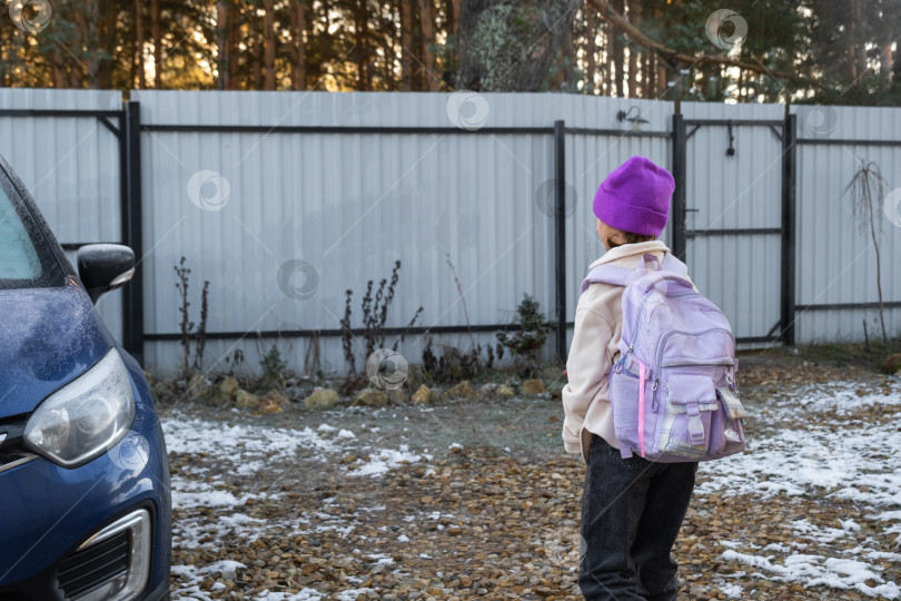 Скачать Девочка утром идет в школу с рюкзаком, во двор к машине фотосток Ozero