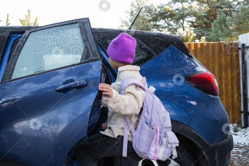 Скачать Девочка с рюкзаком садится в машину, чтобы доехать до школы фотосток Ozero