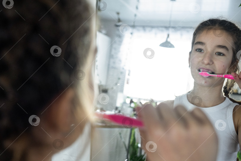 Скачать Девушка чистит зубы по утрам перед зеркалом, гигиена полости рта фотосток Ozero