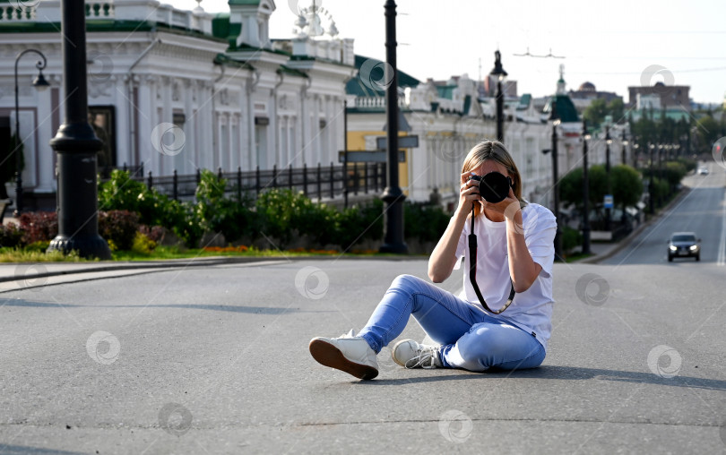 Скачать женщина-фотограф с фотоаппаратом в руках прогуливается по улицам города фотосток Ozero