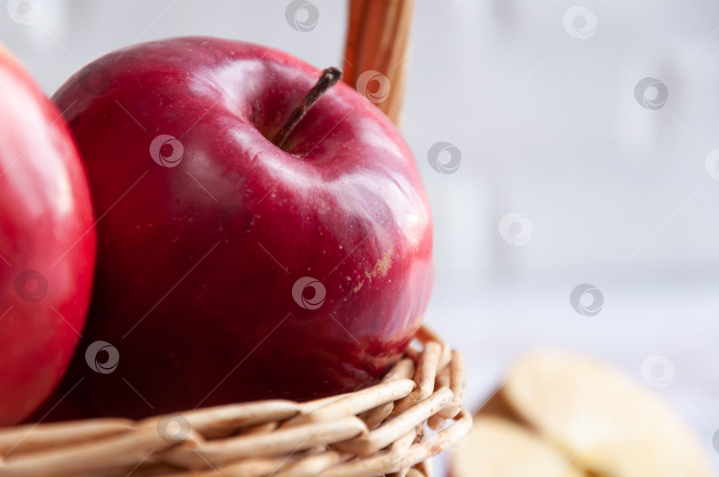Скачать Свежие красные яблоки в плетеной корзинке. Яблоки крупным планом срезать ломтиками. Старая плетеная корзина с фруктами. Избирательный фокус фотосток Ozero