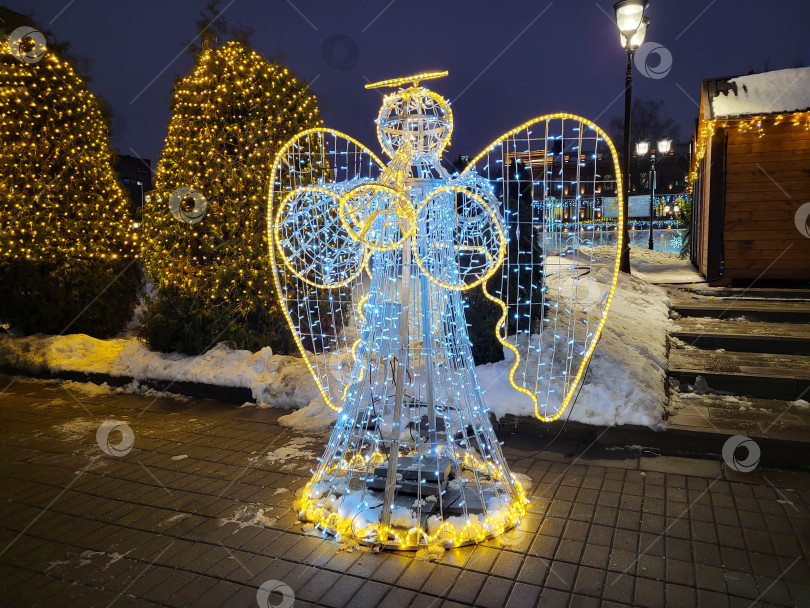 Скачать Россия, Рыбинск, 10.01.2025 Светящаяся фигура ангела с крыльями и трубой в ночи фотосток Ozero