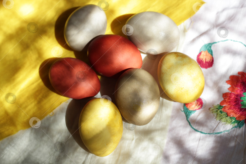 Скачать Домашние пасхальные яйца, окрашенные натуральным способом, лежат на скатерти фотосток Ozero