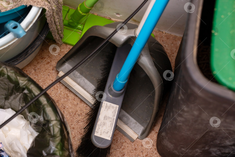 Скачать Старые инструменты для уборки разложены на полу, изношенные принадлежности уборщика разложены на шероховатой бетонной поверхности фотосток Ozero