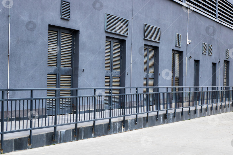 Скачать Индустриально-серый фасад, городская сцена с минималистской архитектурой и резкими полуденными тенями фотосток Ozero