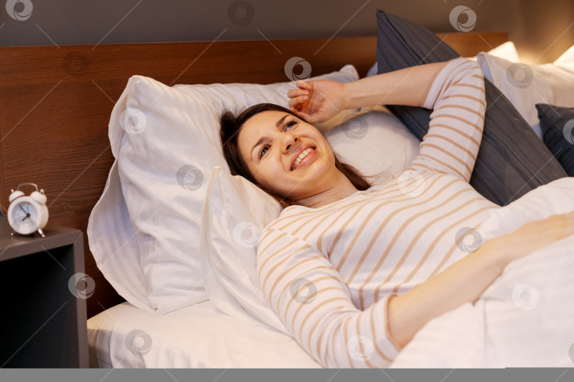 Скачать Женщина лежит в постели с улыбкой на лице фотосток Ozero