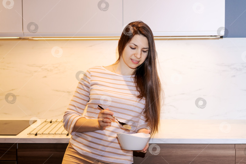 Скачать Женщина ест хлопья на кухне фотосток Ozero