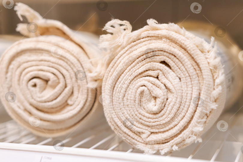 Скачать Два белых полотенца сворачиваются в рулон и кладутся на полку фотосток Ozero