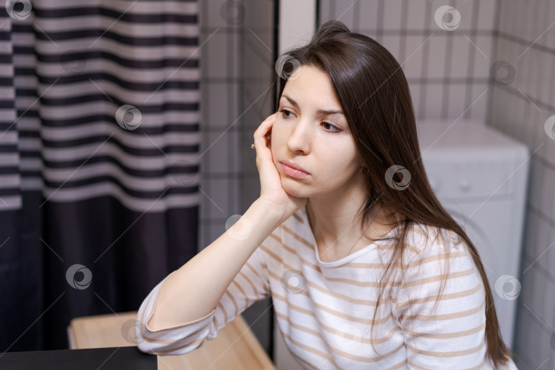 Скачать Женщина сидит за письменным столом, подперев голову рукой фотосток Ozero