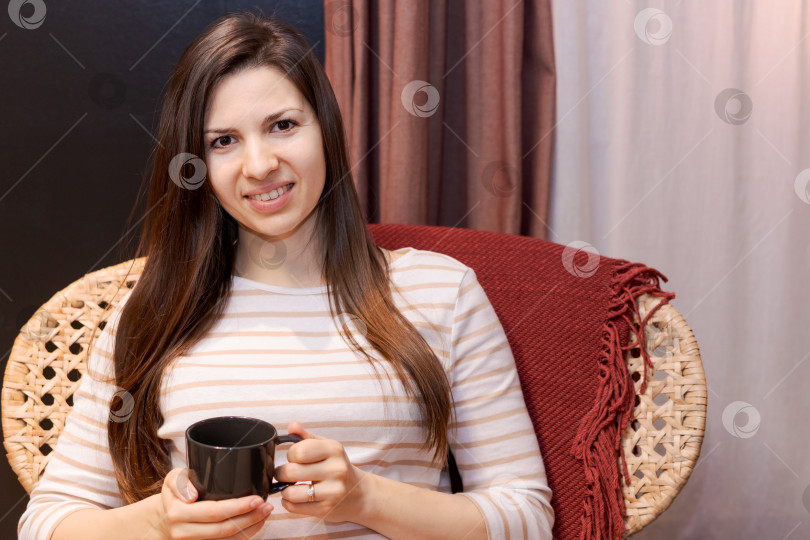 Скачать В кресле сидит женщина с чашкой в руке фотосток Ozero
