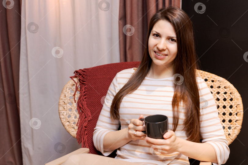 Скачать В кресле сидит женщина с чашкой в руке фотосток Ozero